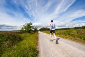 Man jogging outdoors on a dirt road - natural remedies to reduce alcohol cravings
